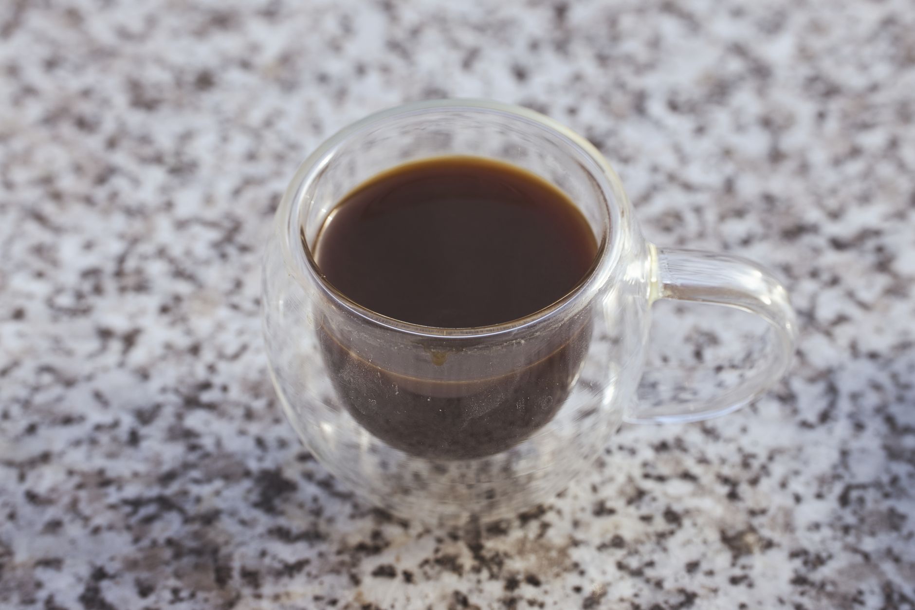 espresso shot glass golden crema surface