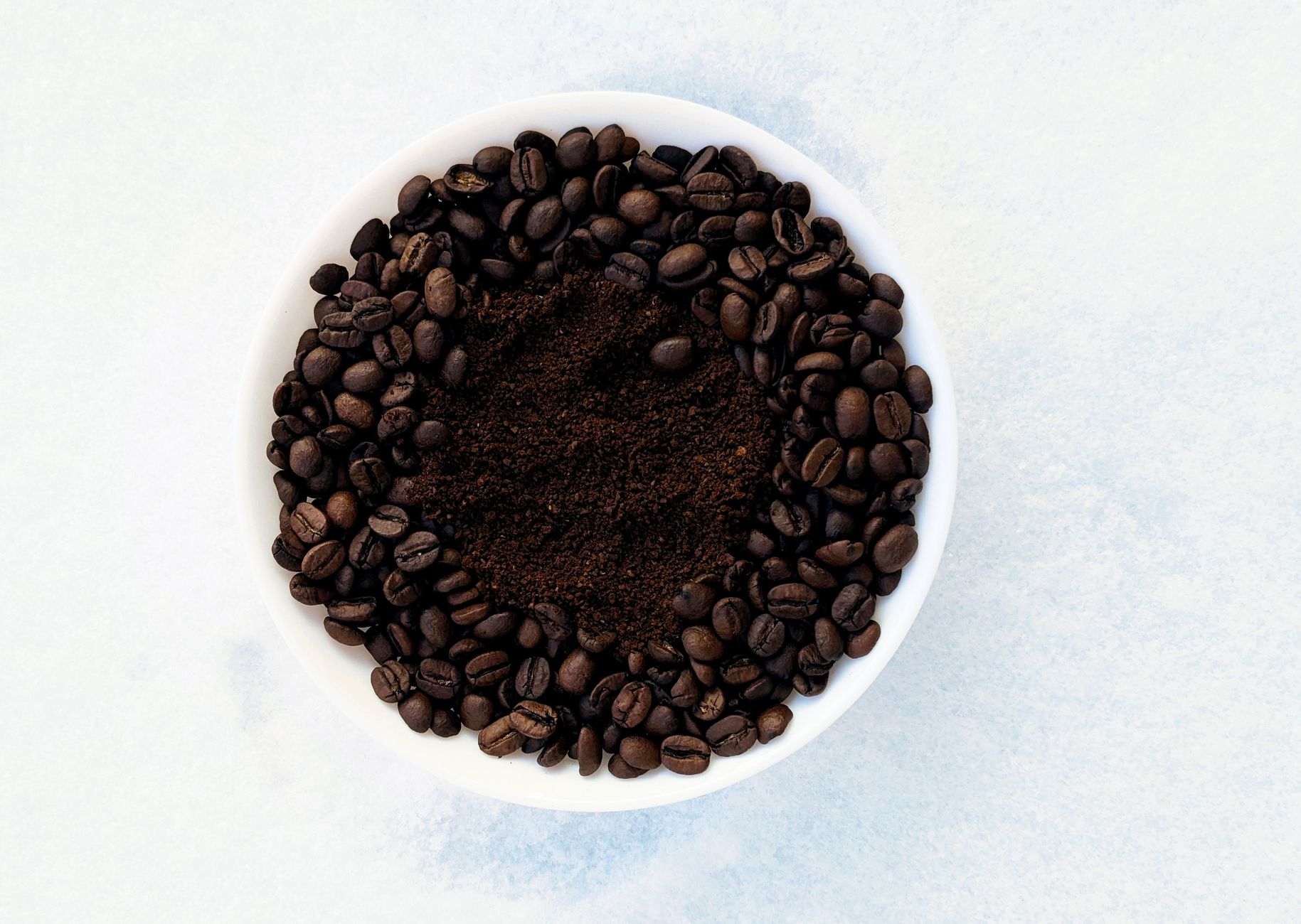 conical burr grinder steel coffee grounds close-up
