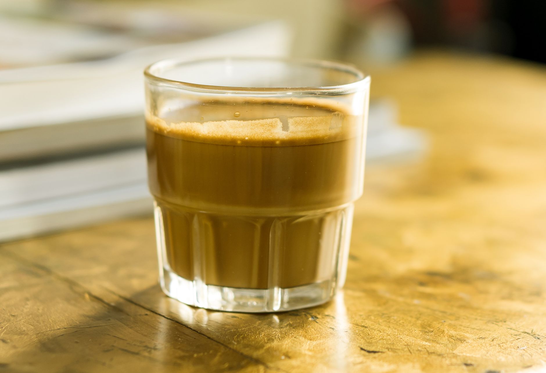 cortado served in small clear glass espresso milk